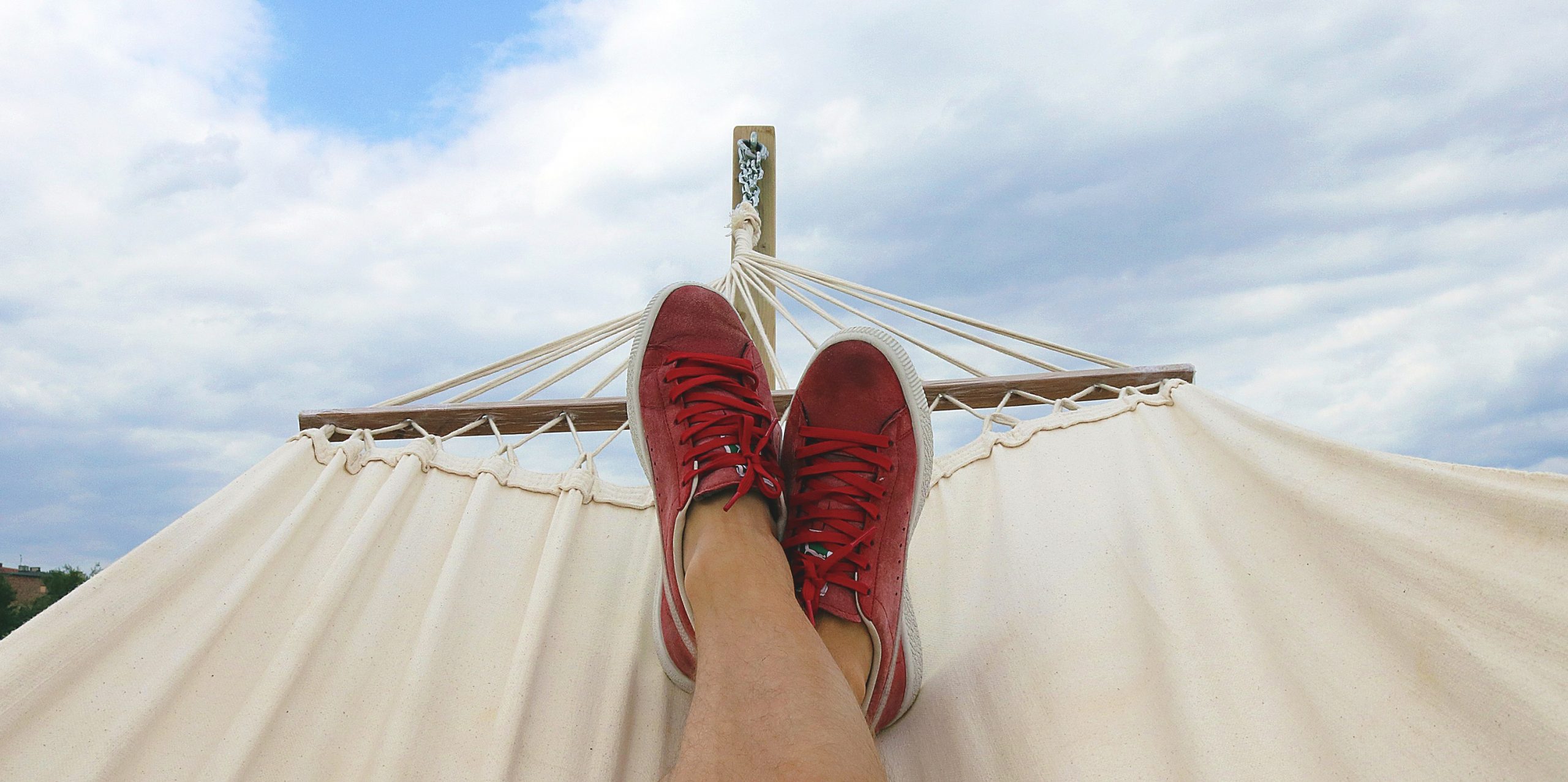 person relaxed on hammock only showing shoes